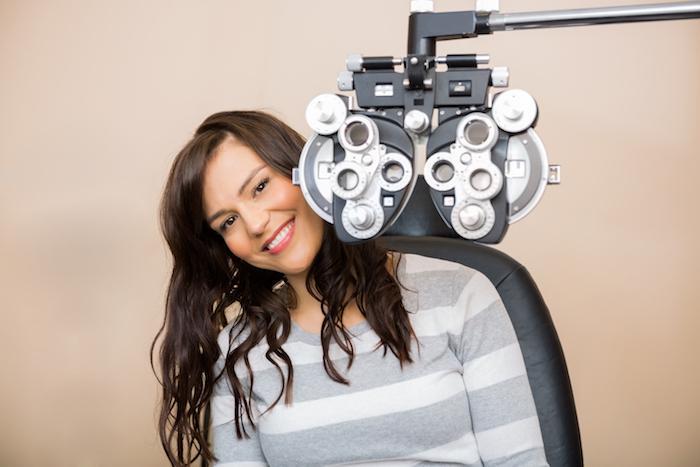 Woman sitting in front of a Phoropter