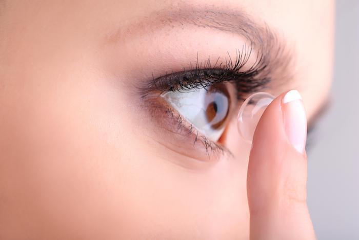 Woman putting in contact lenses